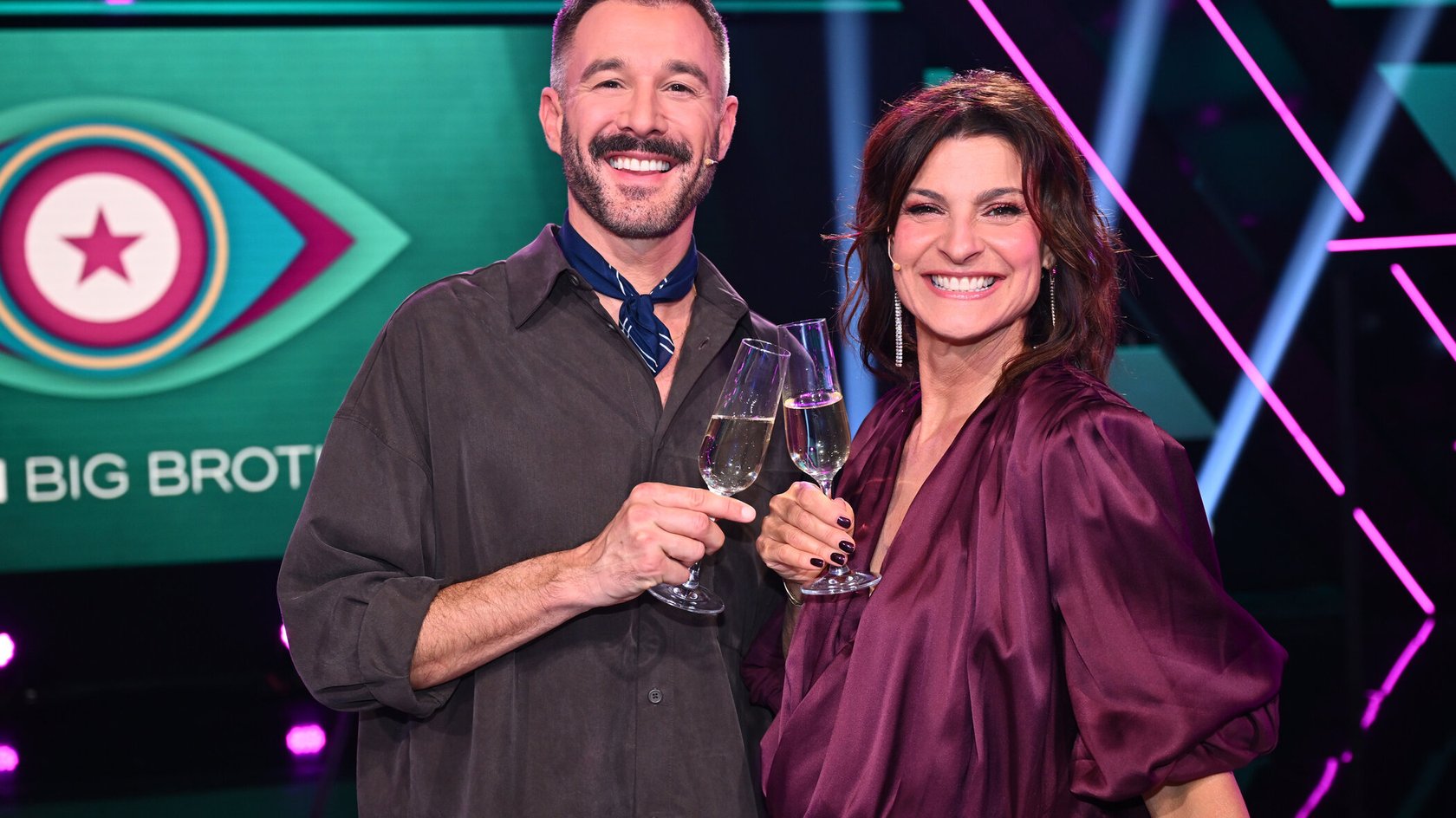 Marlene Lufen und Jochen Schropp stoßen vor dem Promi Big Brother Logo an Marlene Lufen und Jochen Schropp stoßen vor dem Promi Big Brother Logo an