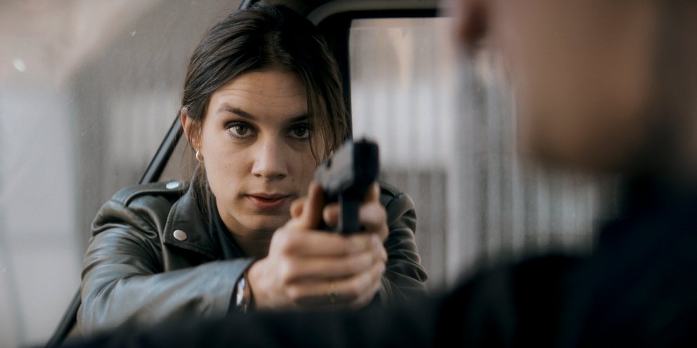Nina bedroht jemanden mit der Waffe